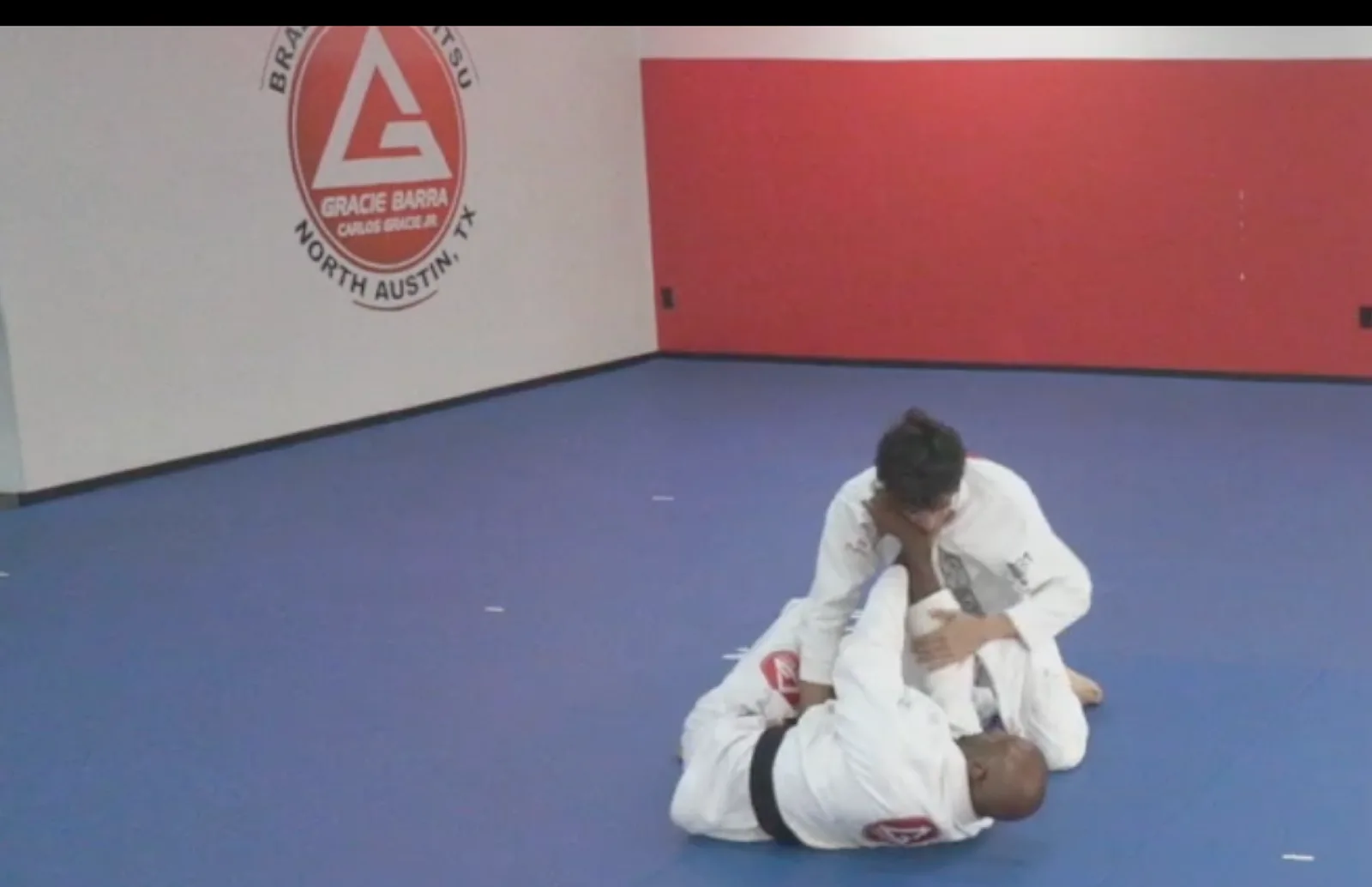 Working a choke from top position on a black belt during training at Gracie Barra North Austin