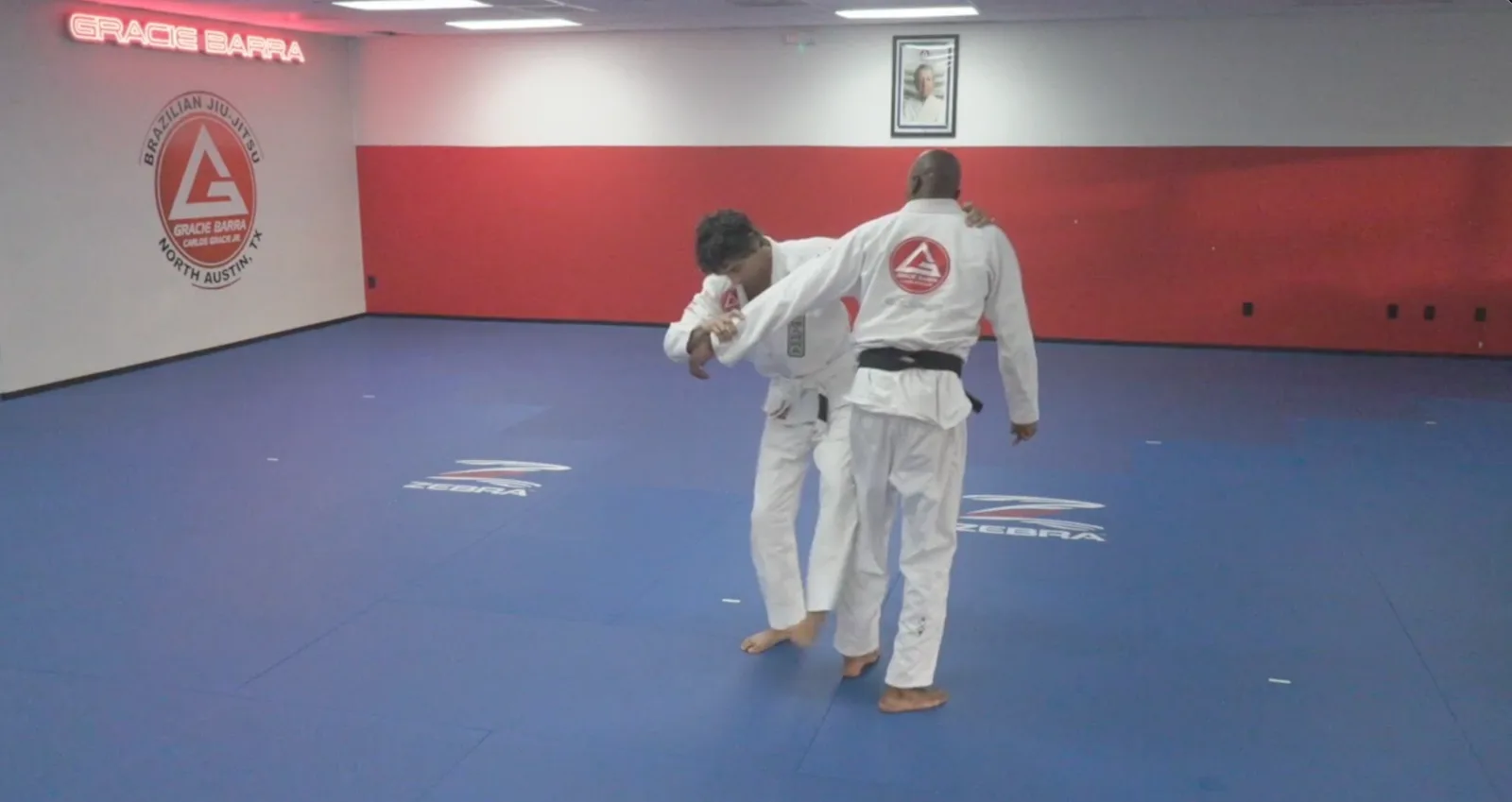 Drilling a standing technique with a black belt on the mats at Gracie Barra North Austin