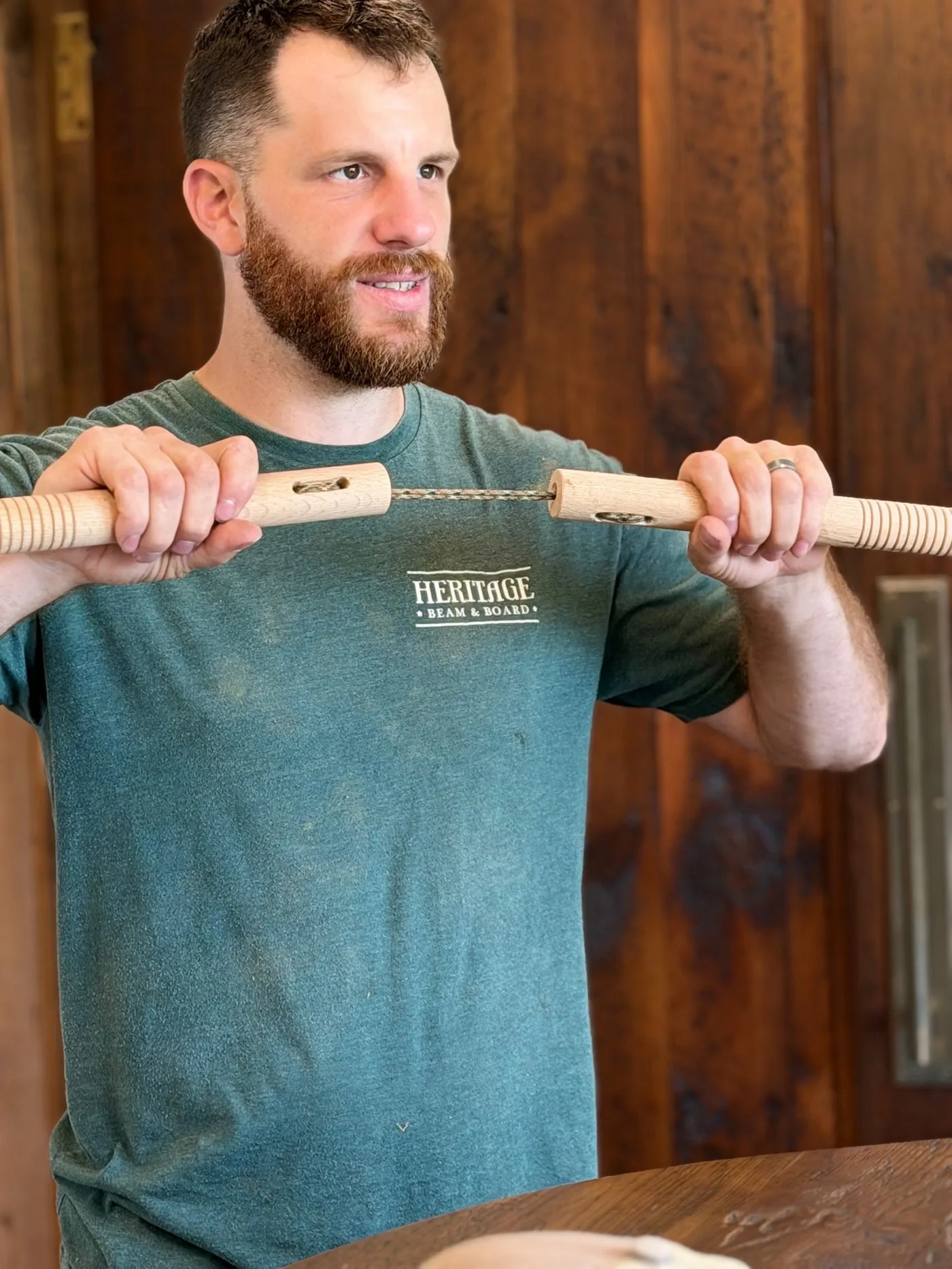 A finished pair of bjj.ac nunchucks held taut by the handles, showing the cut grip rings and the braided paracord connector